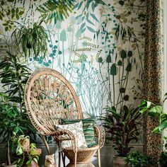 a wicker chair and leopard figurines in front of a wall with plants