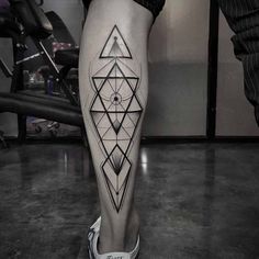 a woman's leg with geometric tattoos on it