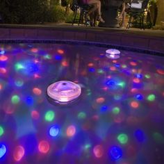 an inflatable pool with lights and people sitting around it