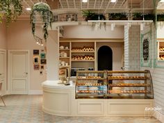 a bakery filled with lots of pastries on display in front of a white brick wall