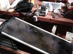 an oven sitting on top of a wooden table next to a bag and other items