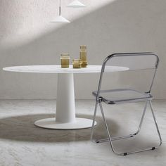 a white table with two chairs next to it and a gold object on the table