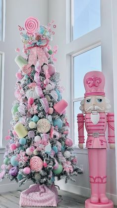 a pink christmas tree with candy decorations and a nutcracker