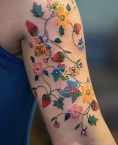 a woman's arm with flowers and leaves painted on the back of her arm