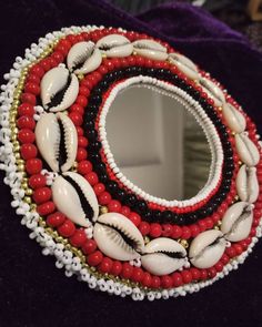 a close up of a mirror with beads and shells on it's side,