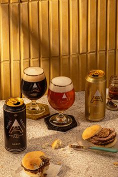 several different types of food and drinks on a table with gold foil covering the wall behind them