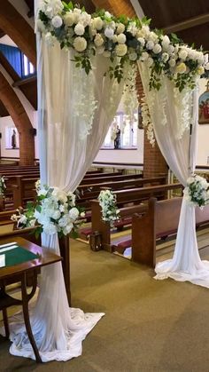 an aisle decorated with white flowers and greenery