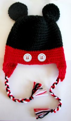 a crocheted mickey mouse hat with two buttons on the front and one ear