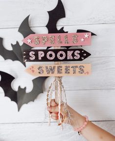 a person holding up a sign that says spoil spooks, sweets and bats