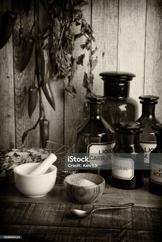 black and white photograph of spices on table with spoons, salt shakers and jars