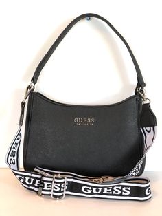 This gorgeous crossbody bag from the renowned brand GUESS is a must-have for every fashion-forward woman out there! With its sleek black exterior made of a combination of faux leather and leather, this medium-sized bag is perfect for everyday use. It features a solid pattern and a zip closure, making it both stylish and secure. The bag has double handles in black and white, as well as a detachable strap, making it versatile to wear. Inside, the bag is lined with brown canvas and has multiple inner pockets for organization. The hardware is silver-colored and the strap has a chic strap accent. This crossbody bag is perfect for women of all ages who appreciate quality and style. Medium Sized Bags, Black Exterior, Brown Canvas, Solid Pattern, Top Handle, Bags Handbags, Fashion Forward, Crossbody Bag, Shoe Accessories