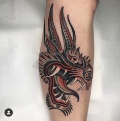 a tattoo design on the leg of a person with an intricate dragon head and claws