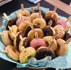 a bowl filled with donuts covered in frosting and sprinkles sitting on top of a table