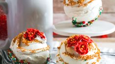 three cakes with white frosting and red flowers on them