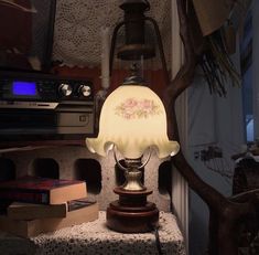 a lamp sitting on top of a table next to a book case and an old fashioned radio