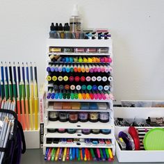 an assortment of markers, pens, and pencils are on display in a storage unit