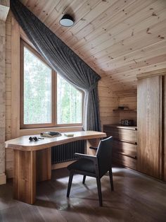 a chair sitting in front of a window next to a desk