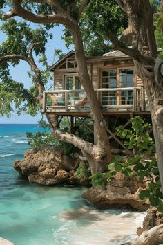 a tree house sitting on top of a cliff next to the ocean