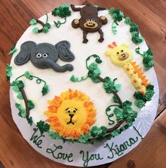 a birthday cake decorated with animals, giraffes and lions