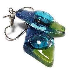 Blue, green, and turquoise glass Earrings. These earrings are handmade of recycled glass. The bubbles are unpredictable the form during the firing process and they give each bead some character and uniqueness! The glass bead is about 1.2 inches long, 0.6inches wide. The earring from the hook to the bottom of the glass is approx 1.9 inches long Sterling silver fish hook wires. All the earrings come with rubber back stoppers. The glass is cut, painted and fired in a kiln. the bead is about one inc Earrings Fuzed Glass, Fused Glass Earrings Recycled Glass Jewelry, Fused Glass Earrings, Green And Turquoise, Diamond Shape Earrings, Silver Fish, Turquoise Glass, Earrings Blue, Diamond Shaped