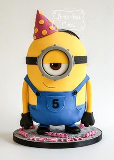 a birthday cake with a minion wearing a party hat