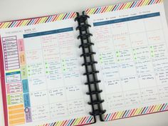 a planner is open on top of a white table with colorful stripes and lines around it