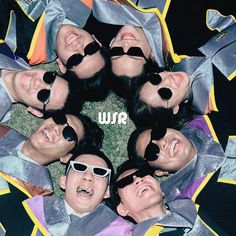 a group of men wearing sunglasses are in a circle with their heads tilted to the side