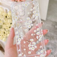 a person holding a clear case with white flowers on it