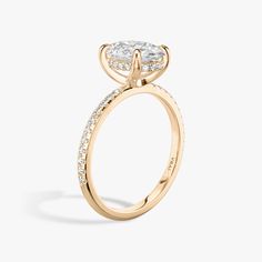 a yellow gold engagement ring with an oval cut diamond on the center and side stones