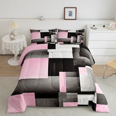 a bed with pink and black comforters in a room next to a white chair