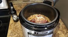 an open crock pot with food in it sitting on a counter next to a stove