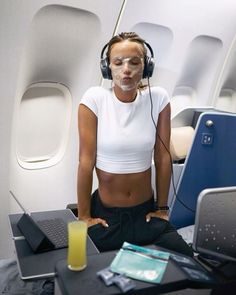 a woman wearing headphones sitting in front of a laptop computer