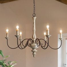 a chandelier hanging from the ceiling with lit candles