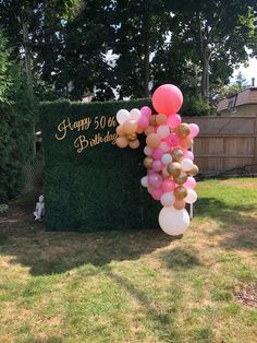 a birthday sign with balloons attached to it