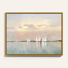 sailboats are sailing on the water in front of a sunset sky with white clouds