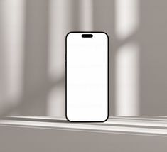 an iphone sitting on top of a window sill in front of a white wall