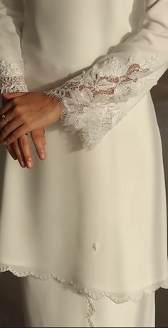 a woman in a white dress holding her hands together