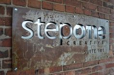 a sign on the side of a brick building that says steoona creative suite