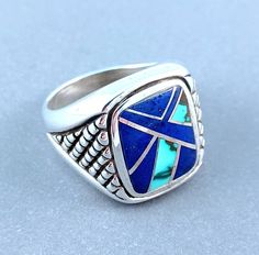 This sterling silver handcrafted men's ring features hand inlaid natural turquoise and lapis lazuli. The inlay incorporates sterling silver straps and is high polished.  Size 10 This ring can NOT be resized. Please contact me for a custom ring made in your size. Adjustable Sterling Silver Ring With Inlay, Artisan Blue Ring Stamped 925, Collectible Blue Inlay Rings, Sterling Silver Inlay Jewelry, San Diego Shopping, Silver Mens Ring, Turquoise Men, Man Ring, Biker Rings