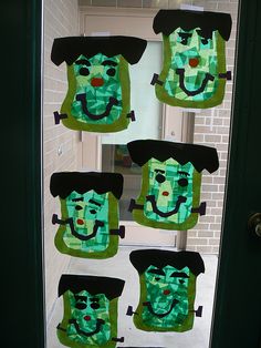 the door is decorated with green and black paper cutouts that have faces on them