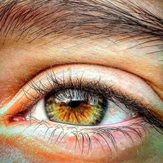 an orange and yellow eye is shown in this close up photo, with the iris partially visible