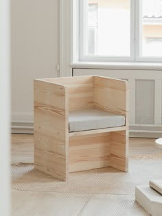 a wooden chair sitting on top of a hard wood floor next to a white window