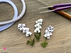 several pieces of paper sitting on top of a wooden table next to scissors and thread