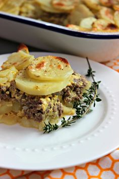 a white plate topped with food next to a casserole dish filled with potatoes