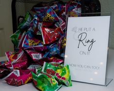 a pile of candy sitting on top of a table next to a sign that says he put a ring on it