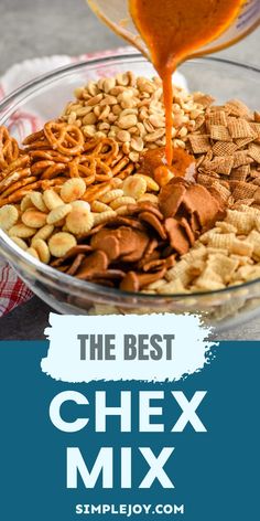 the best chex mix is in a glass bowl and being drizzled with orange sauce