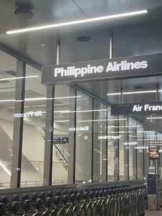 an airport terminal with luggage carts lined up in front of the doors and windows that read, philippines airlines