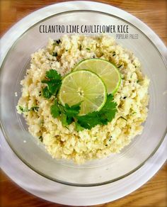 a bowl filled with rice, lime and cilantro