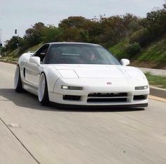 a white sports car driving down the road