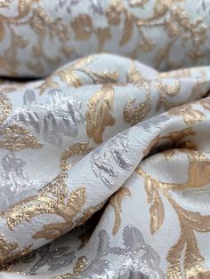 a close up view of a gold and white floral pattern on an unlined fabric